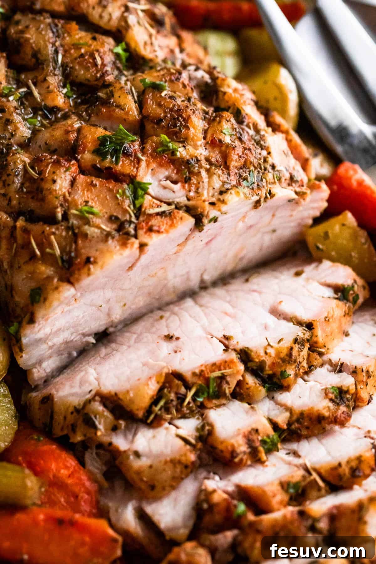 Herb-Crusted Pork Loin with Roasted Root Vegetables 7 up close shot of baked pork loin roast sliced and served with vegetables