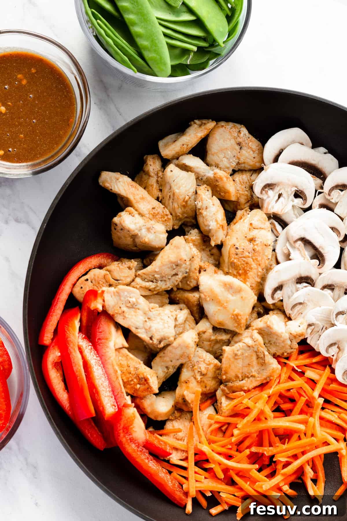 Flavorful Chicken Noodle Stir-Fry 5 Cooked Chicken, Shredded Carrots, Mushrooms and Red Pepper Slices in a Skillet Beside the Other Ingredients