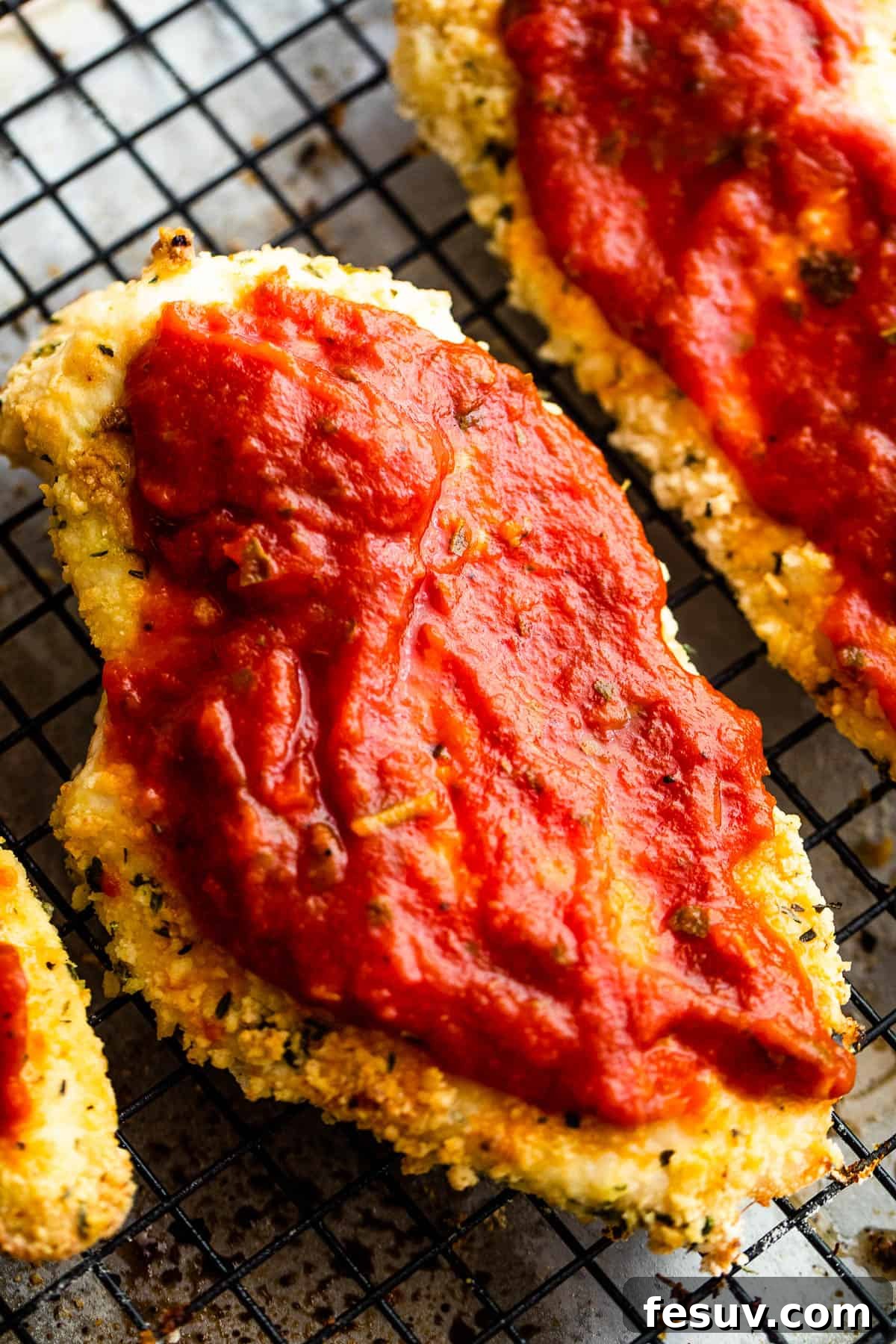 Crispy Air Fryer Chicken Parmesan 7 Two Pieces of Partially Cooked, Breaded Chicken with Marinara Sauce Spread on Top