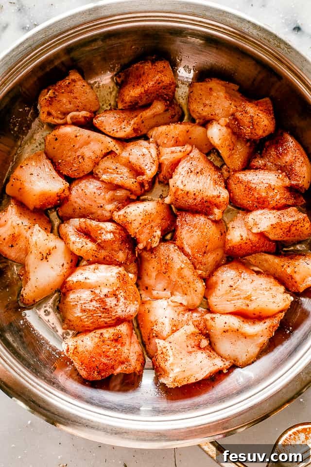 Cooking flavorful chicken bites in a non-stick pan. Taco chicken bites sizzling and browning in a hot skillet with olive oil.