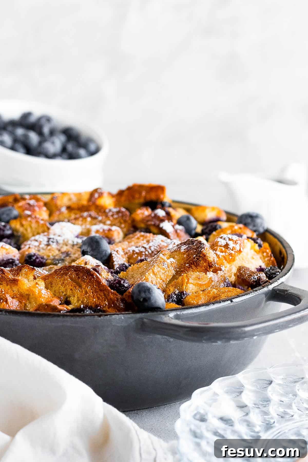 Sweet Blueberry French Toast Bake 7 A Perfectly Baked Blueberry French Toast Casserole in a Round Pan, Generously Topped with Powdered Sugar