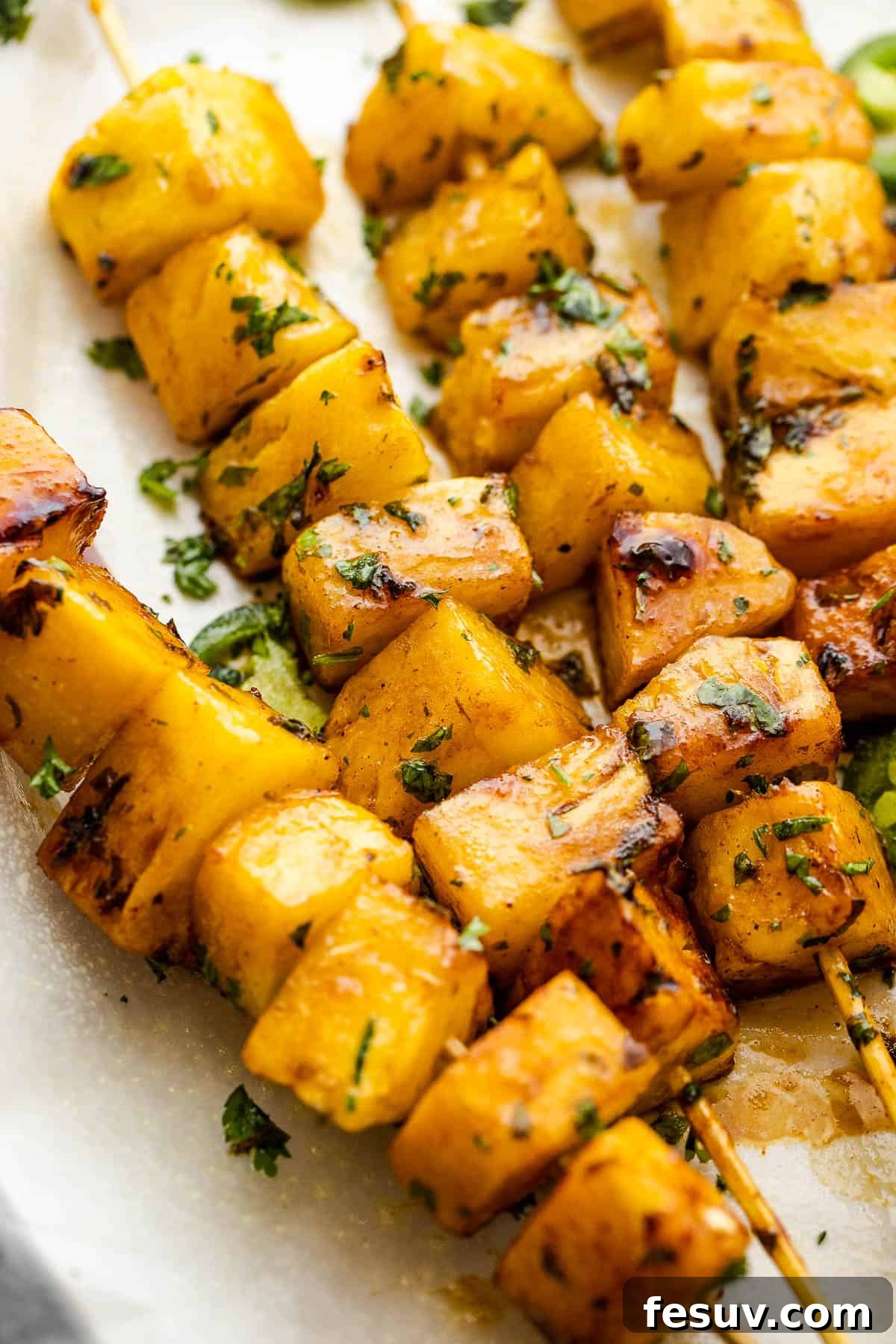 Tequila-Kissed Grilled Pineapple 7 side shot of pineapple skewers topped with chopped cilantro