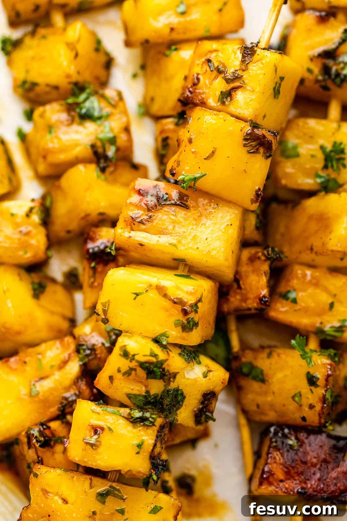 Tequila-Kissed Grilled Pineapple 8 close up shot of grilled pineapple skewers served on a plate