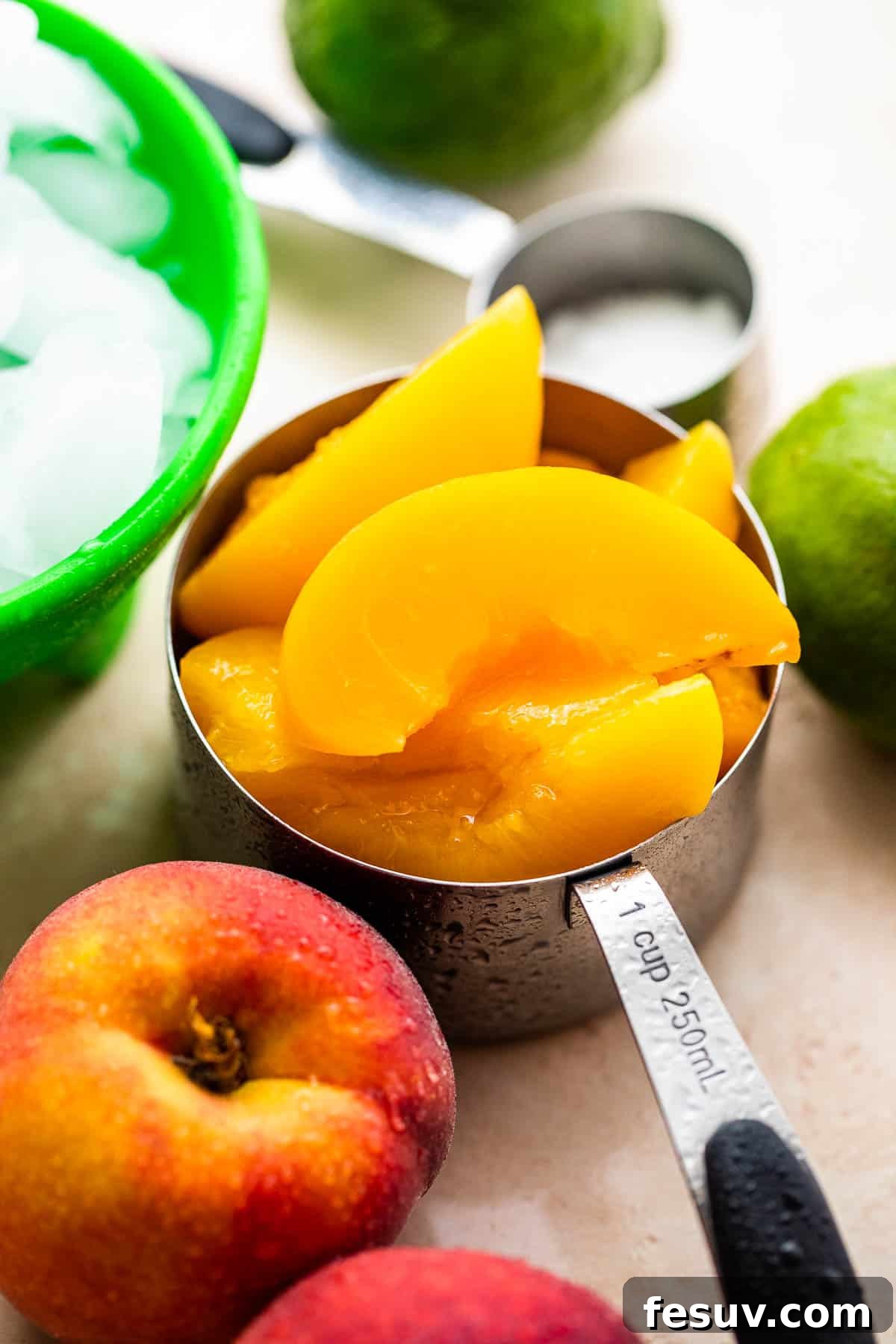 fresh sliced peaches in a stainless measuring cup