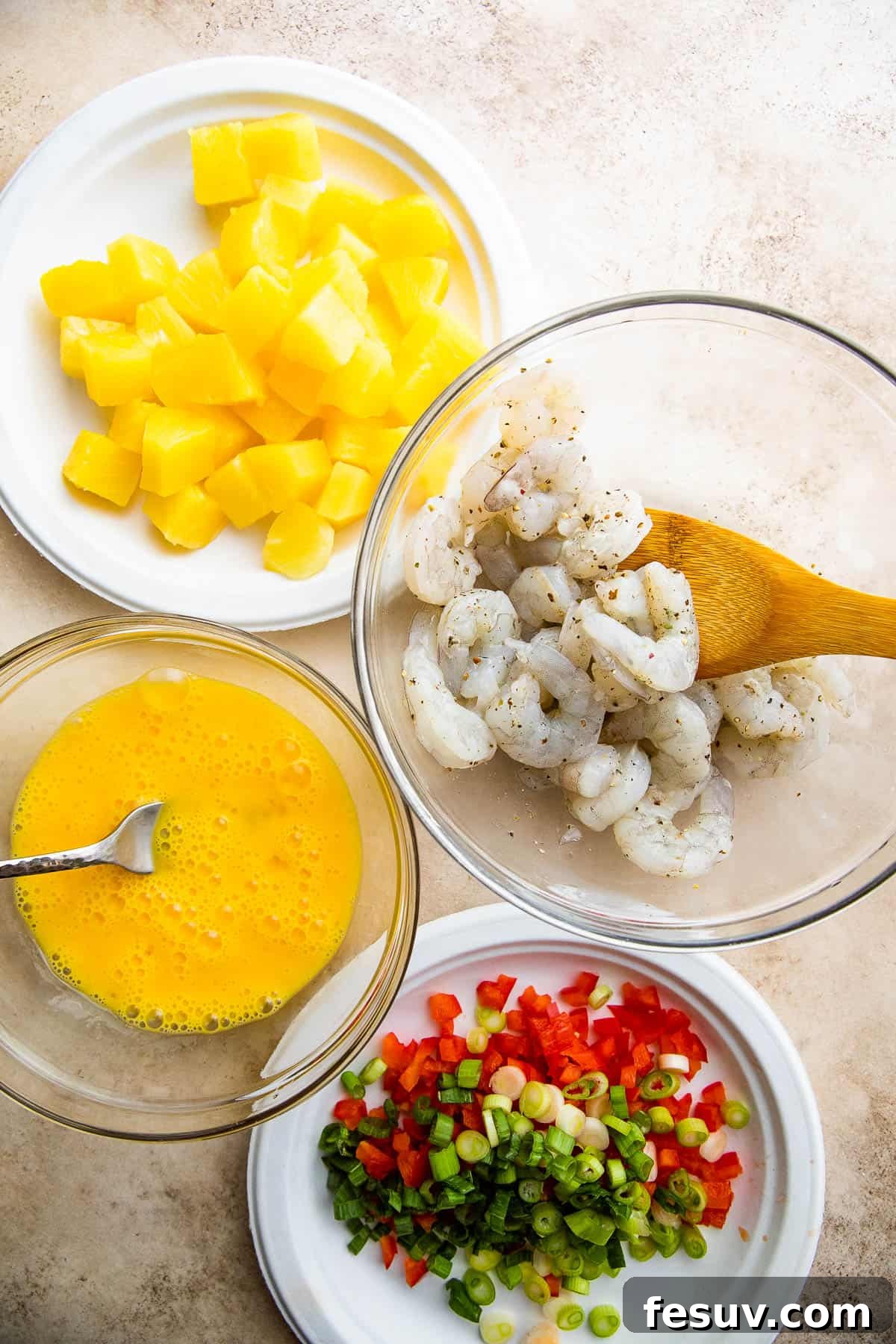 Tropical Pineapple Shrimp Fried Rice 4 Individual bowls containing prepped ingredients for shrimp fried rice, including shrimp, pineapple, vegetables, and rice.