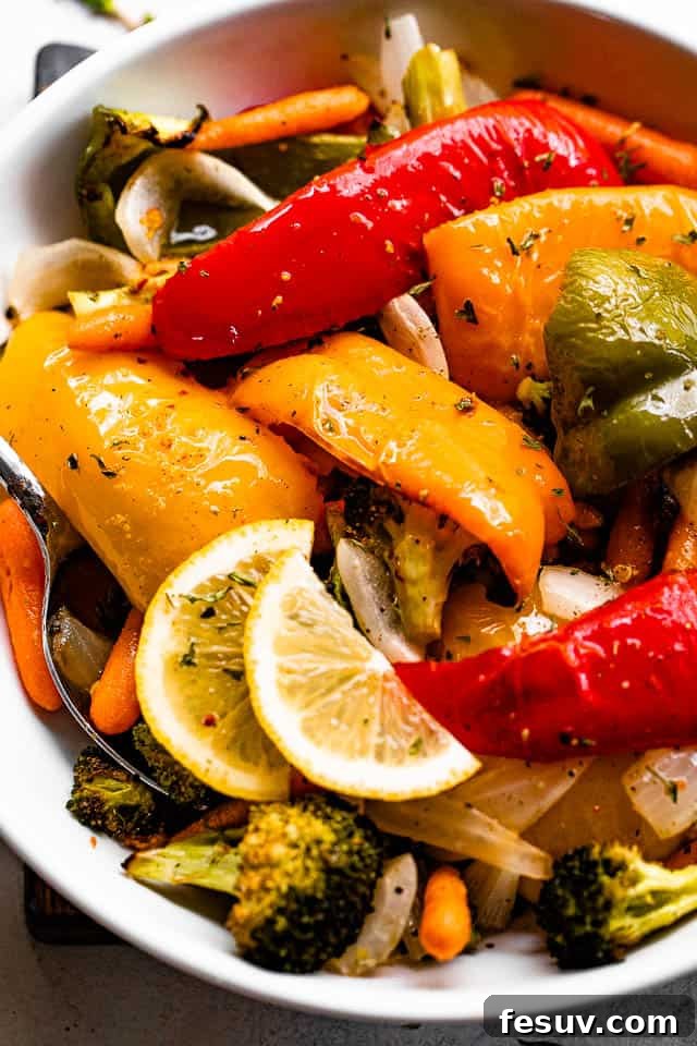 Zesty Grilled Vegetable Medley 2 grilled vegetables served in a white bowl and garnished with lemon slices