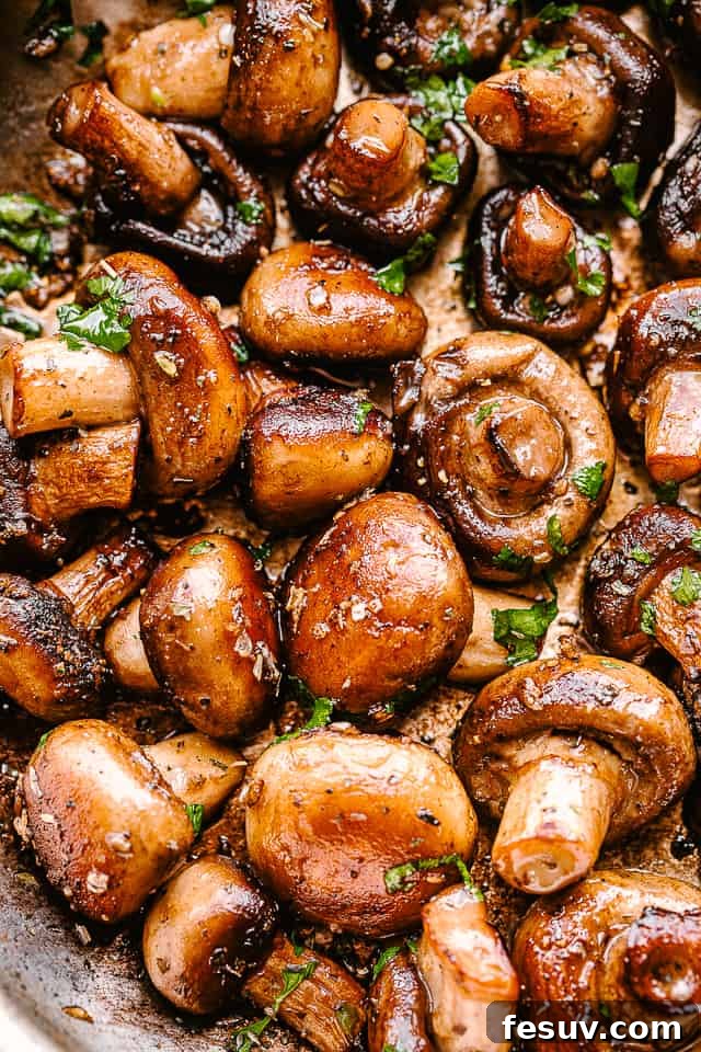 Close-up of sautéed garlic butter mushrooms with fresh parsley. A vibrant close-up of garlic butter mushrooms, showcasing their golden-brown hue, glistening butter, and fresh green parsley.