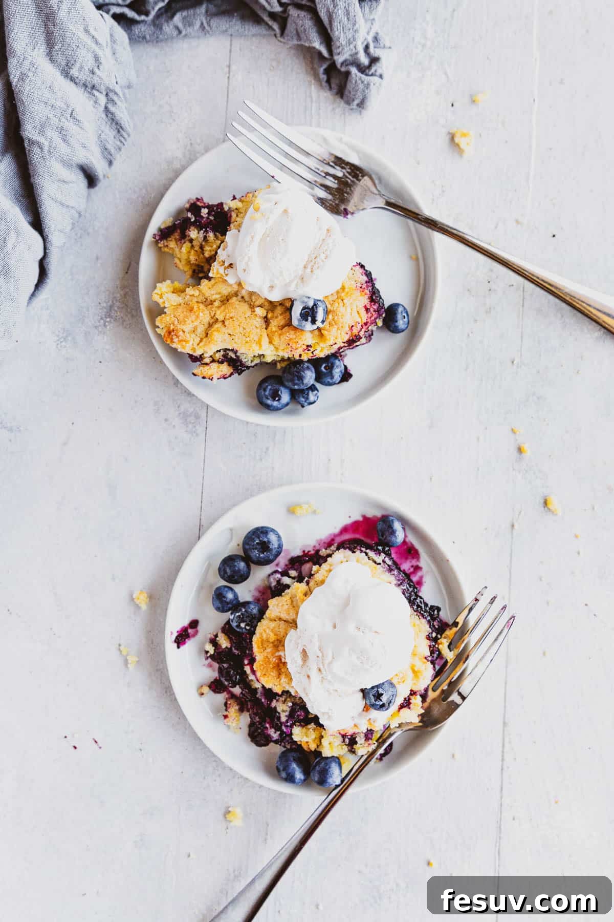 overhead view of two white plates with Blueberry Rhubarb Cobbler