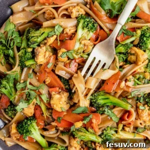 Thai Wide Noodle Perfection 11 A Fork Digging Into a Big Plate of Pad See Ew