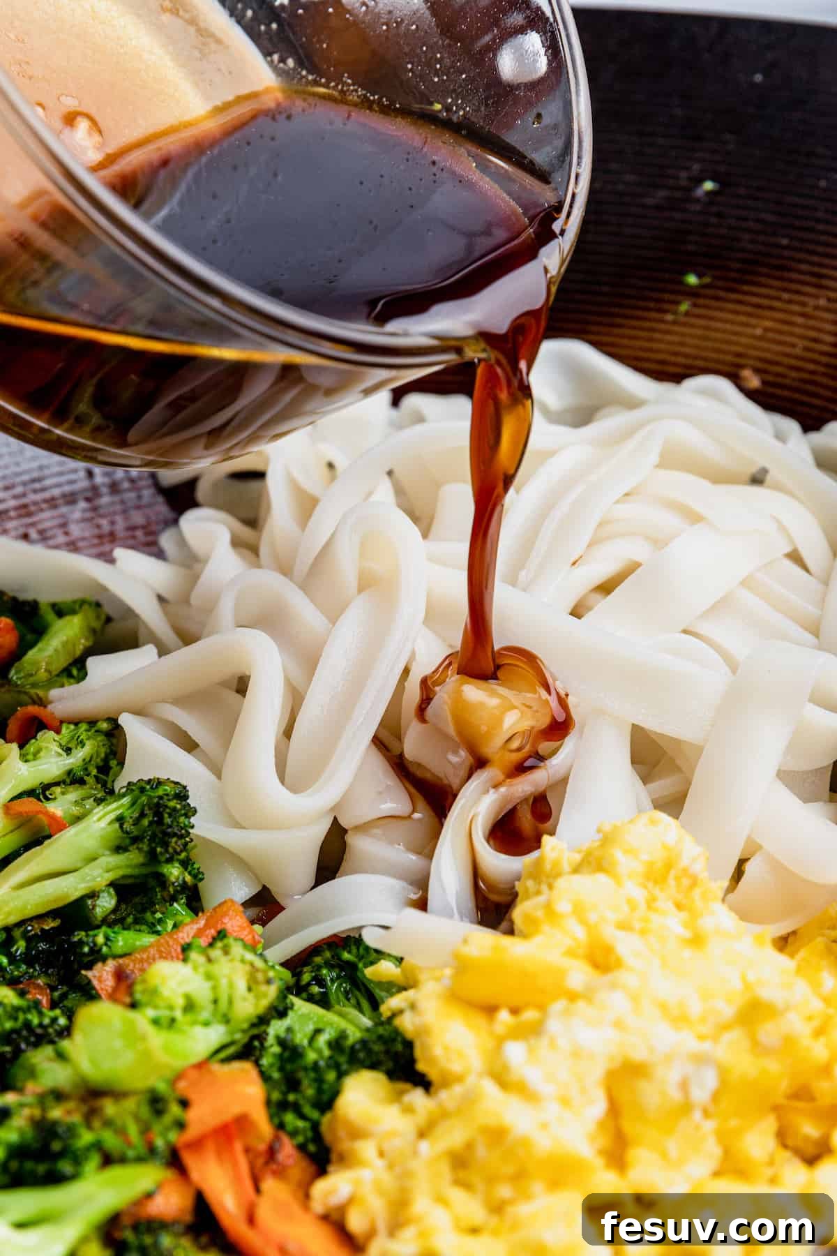 Thai Wide Noodle Perfection 7 Pad See Ew Sauce Being Added to the Noodles, Eggs and Veggies in the Bowl