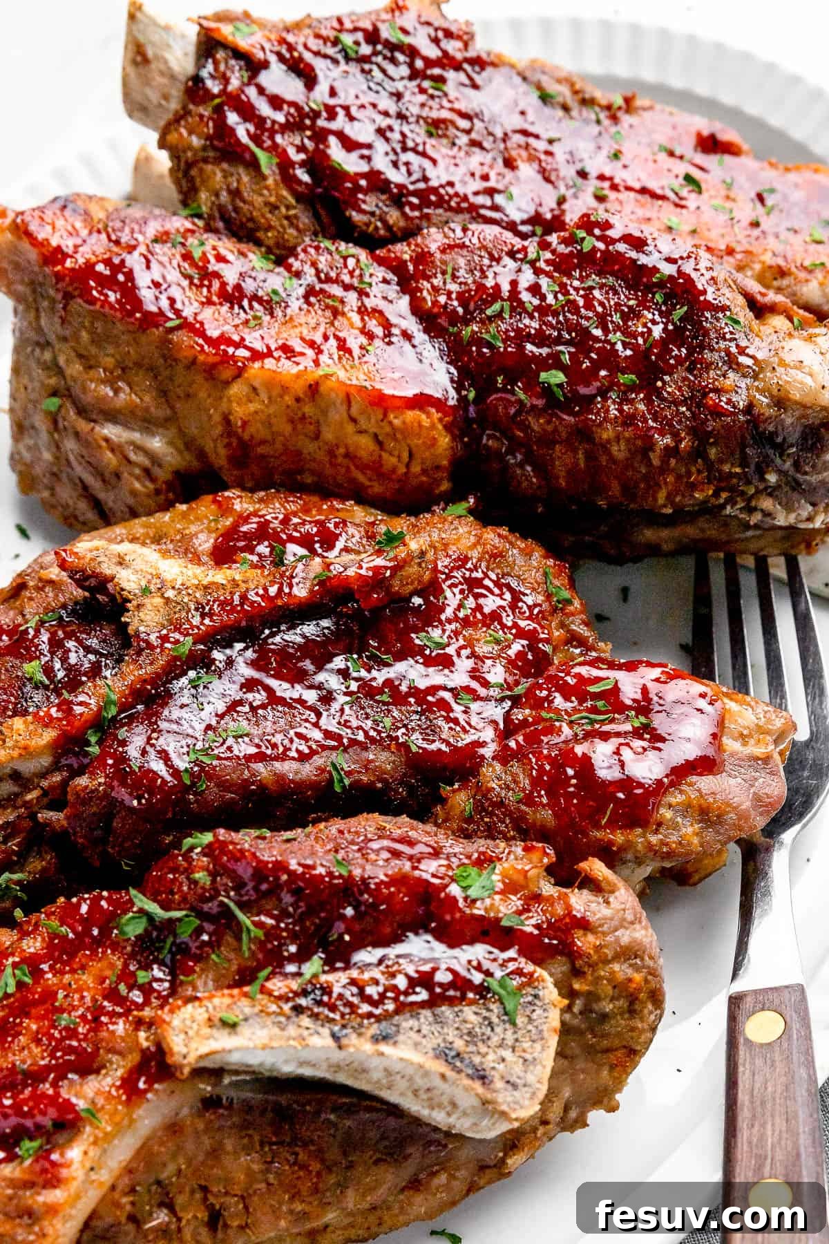 Fall-Off-The-Bone Instant Pot Ribs 3 Side shot of Instant Pot Ribs on a white serving platter with a small salad in the background, highlighting the golden-brown crust