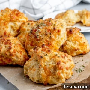 Six Air Fryer Biscuits on a Piece of Parchment Paper Over a Wooden Board