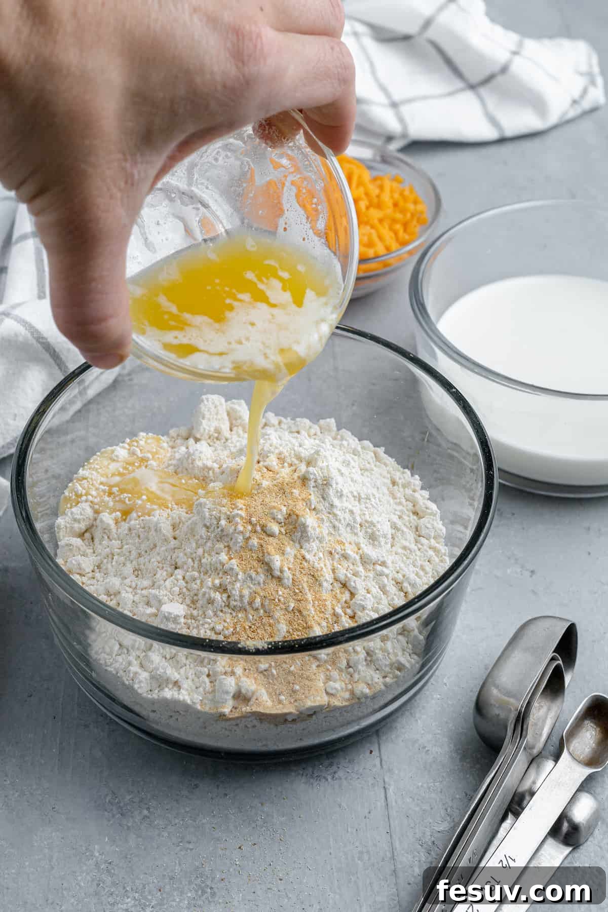 Melted Butter Being Poured Over a Bowl of Bisquick Mix