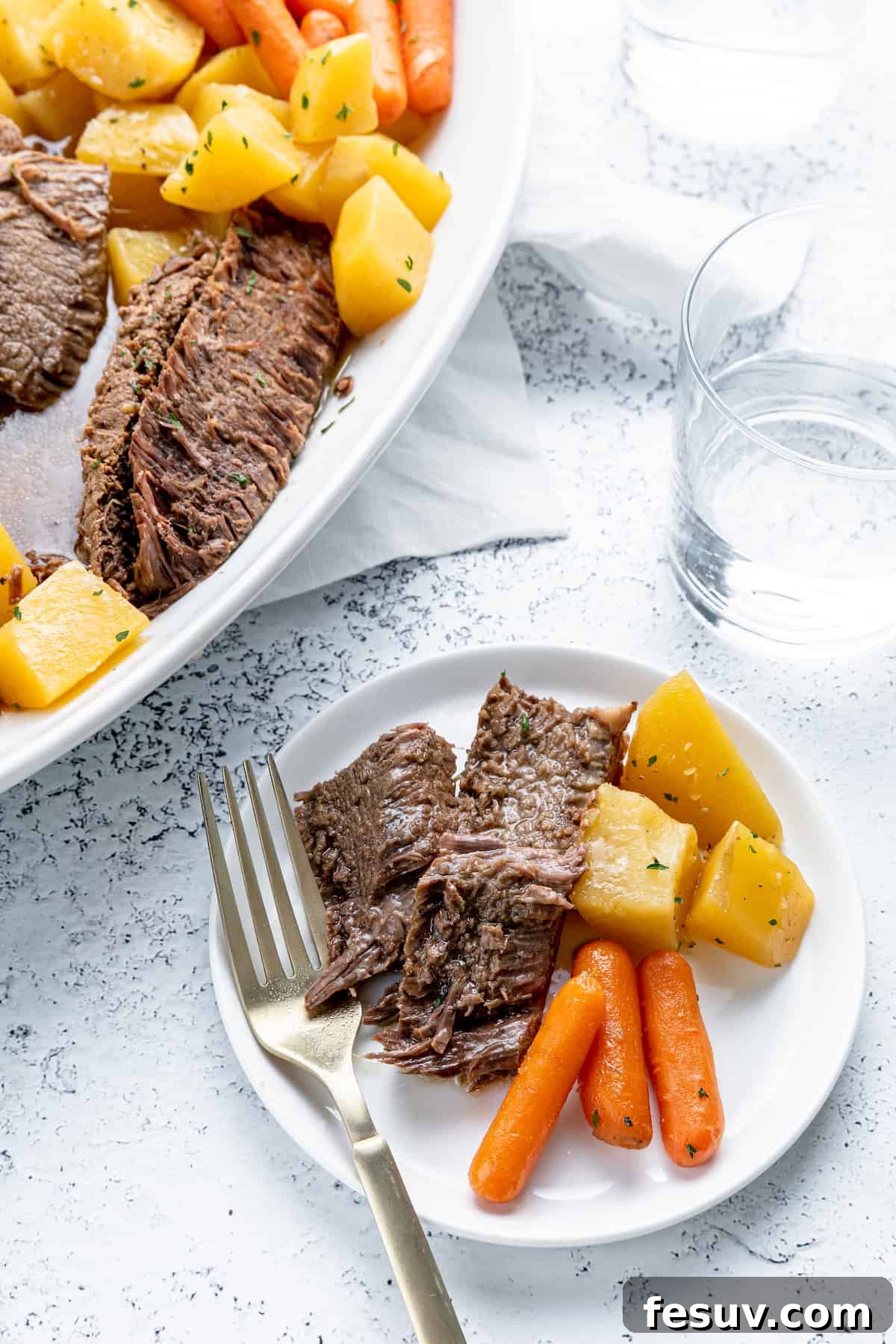 Savory Instant Pot Pot Roast with Hearty Root Vegetables 8 A beautifully arranged serving of pot roast, carrots, and potatoes on a white plate, ready to be enjoyed.