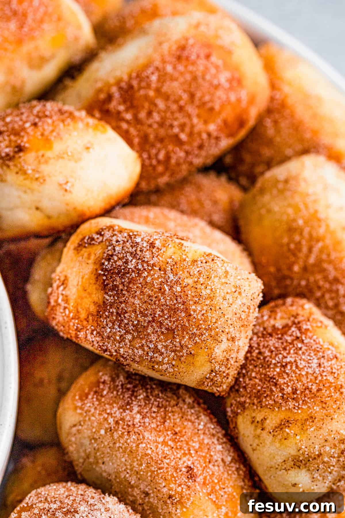 A stack of golden-brown cinnamon sugar pretzel bites, ready to be enjoyed.