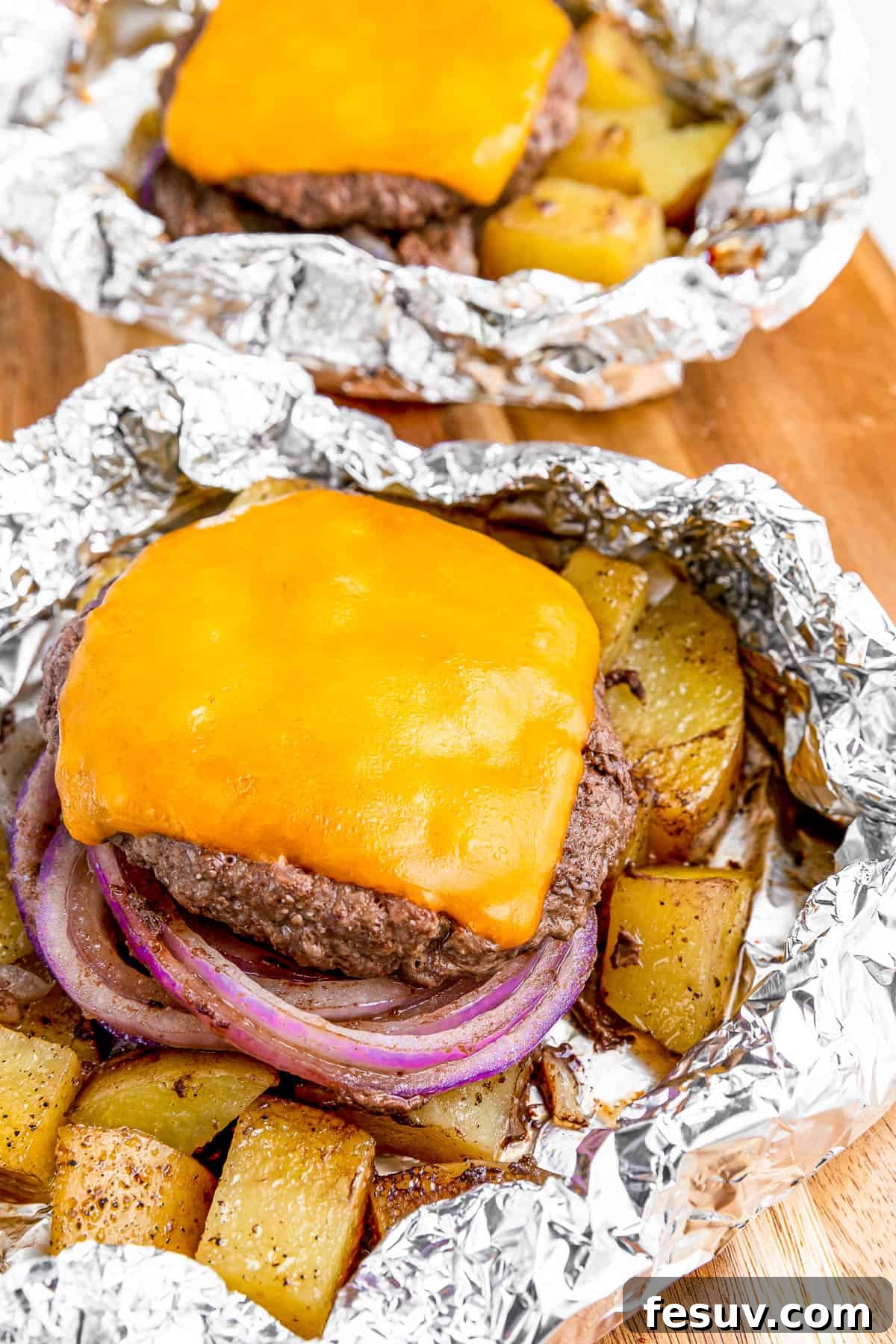 Hearty Cheeseburger Foil Packs with Potatoes and Vegetables 2 Cheeseburger in foil with melted cheese