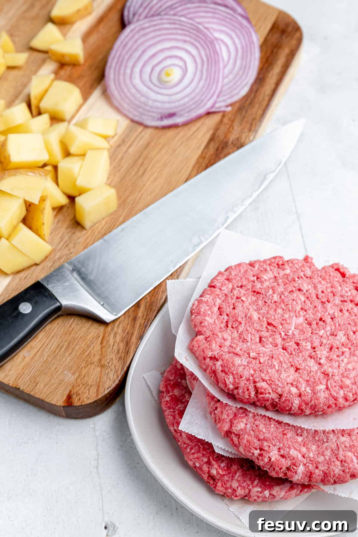 Hearty Cheeseburger Foil Packs with Potatoes and Vegetables 3 A beef patty, diced potatoes, onions and a knife