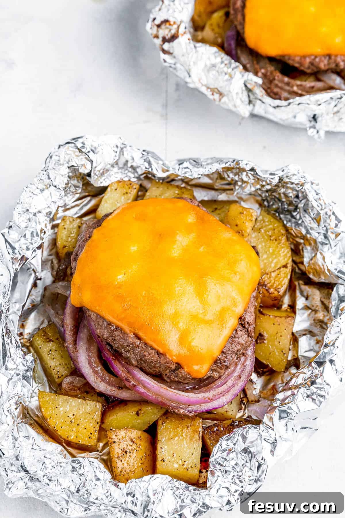 Hearty Cheeseburger Foil Packs with Potatoes and Vegetables 5 Two cheeseburgers in foil with potatoes