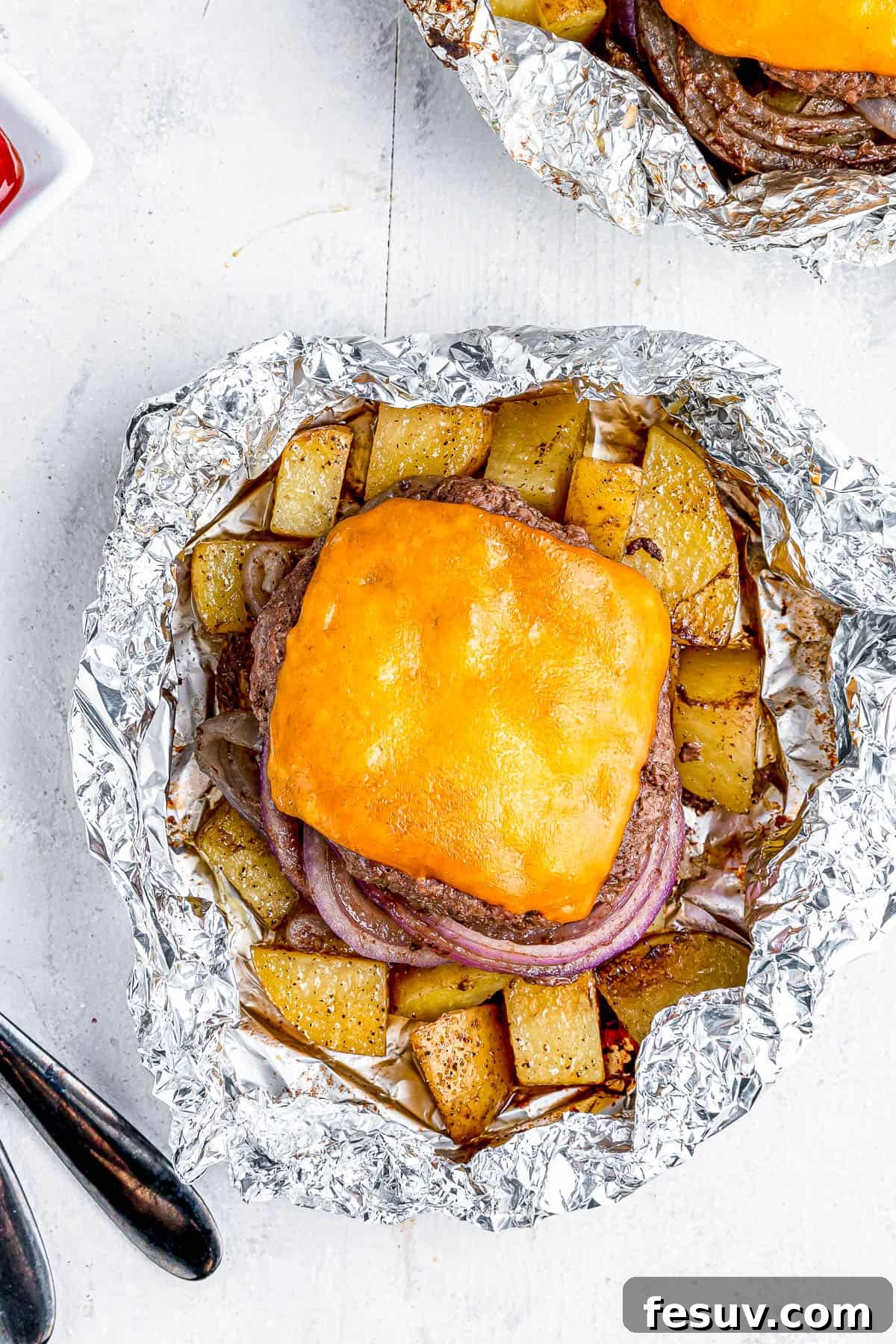 Hearty Cheeseburger Foil Packs with Potatoes and Vegetables 7 Two cheeseburgers in foil with potatoes