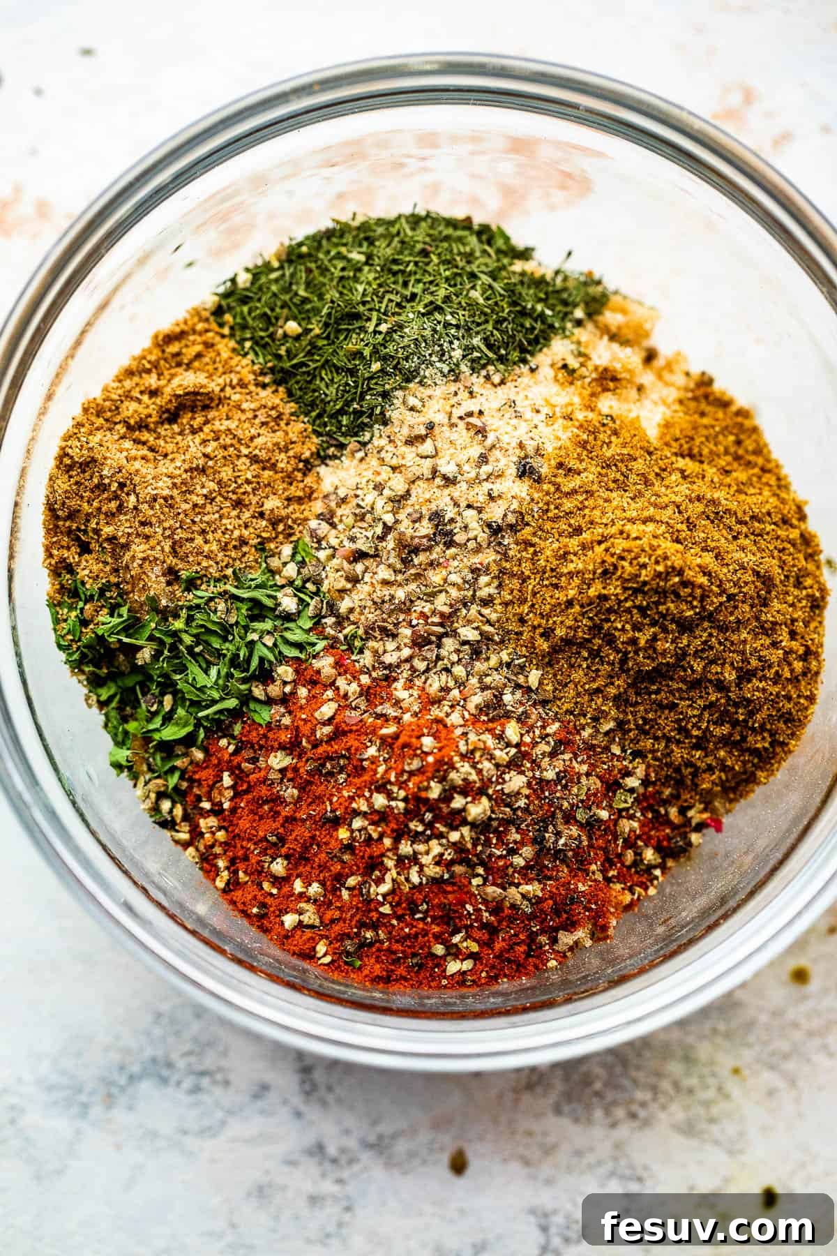 Overhead view of a glass jar filled with homemade seafood seasoning, showcasing its rich color and texture.