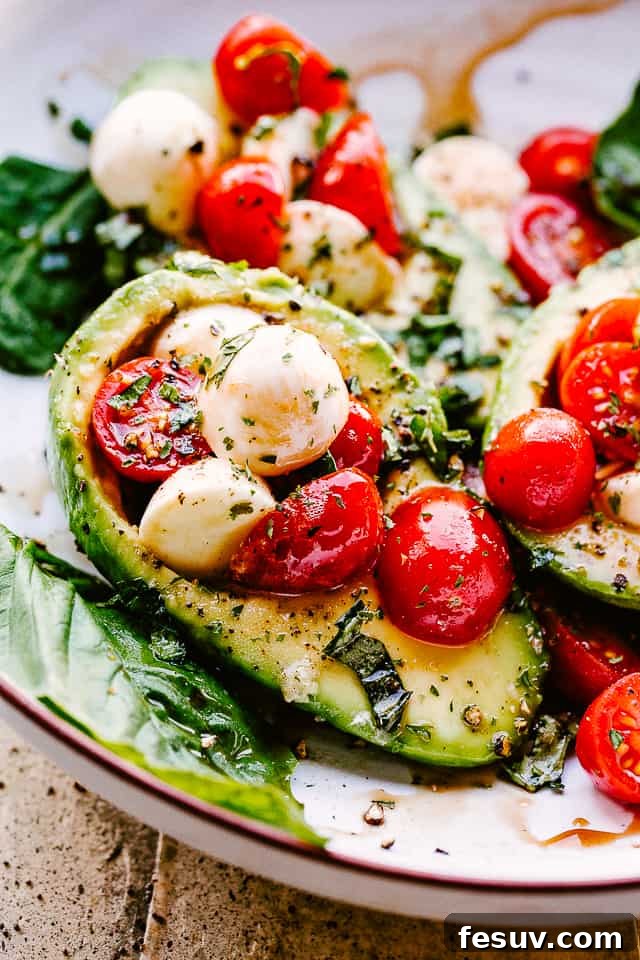 Caprese Stuffed Avocados served on a plate, showcasing the vibrant colors of fresh tomatoes, mozzarella, and basil against the creamy avocado.