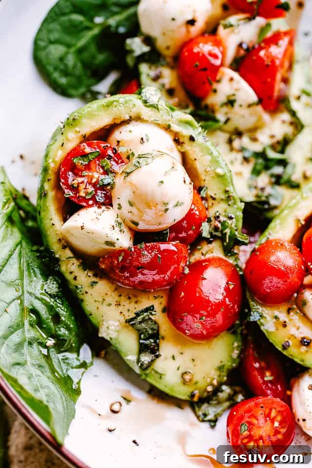A close-up shot of Caprese Stuffed Avocados, highlighting the detailed texture and vibrant colors of the ingredients.
