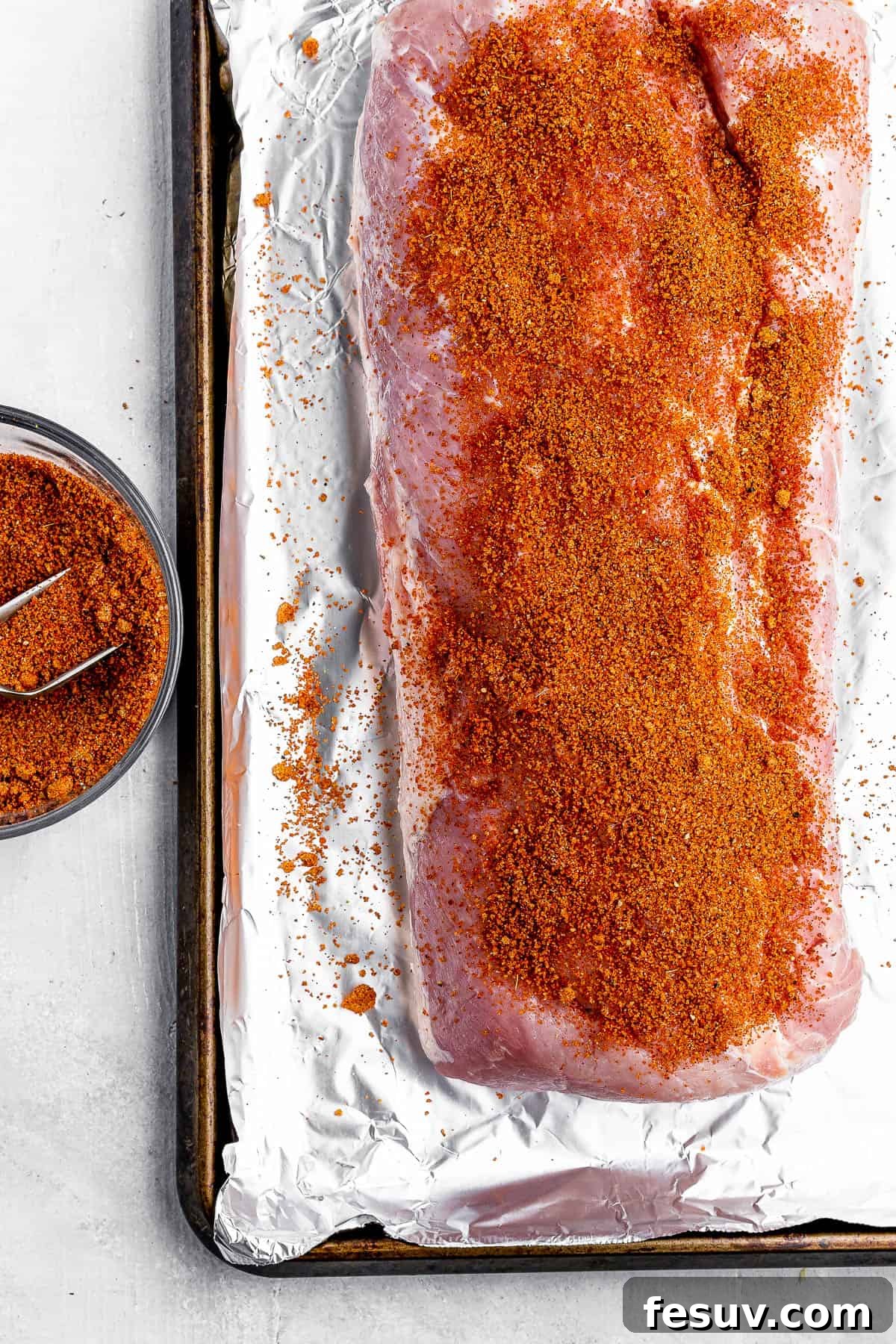 Effortless Instant Pot Pulled Pork with Zesty Coleslaw 4 Raw pork roast generously coated with a dark, smoky seasoning rub on a baking sheet