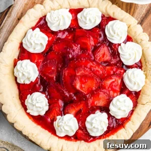 overhead shot of strawberry pie garnished with dollops of cream