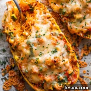 Spaghetti squash stuffed with chicken enchilada filling and topped with melted cheese, ready to serve.