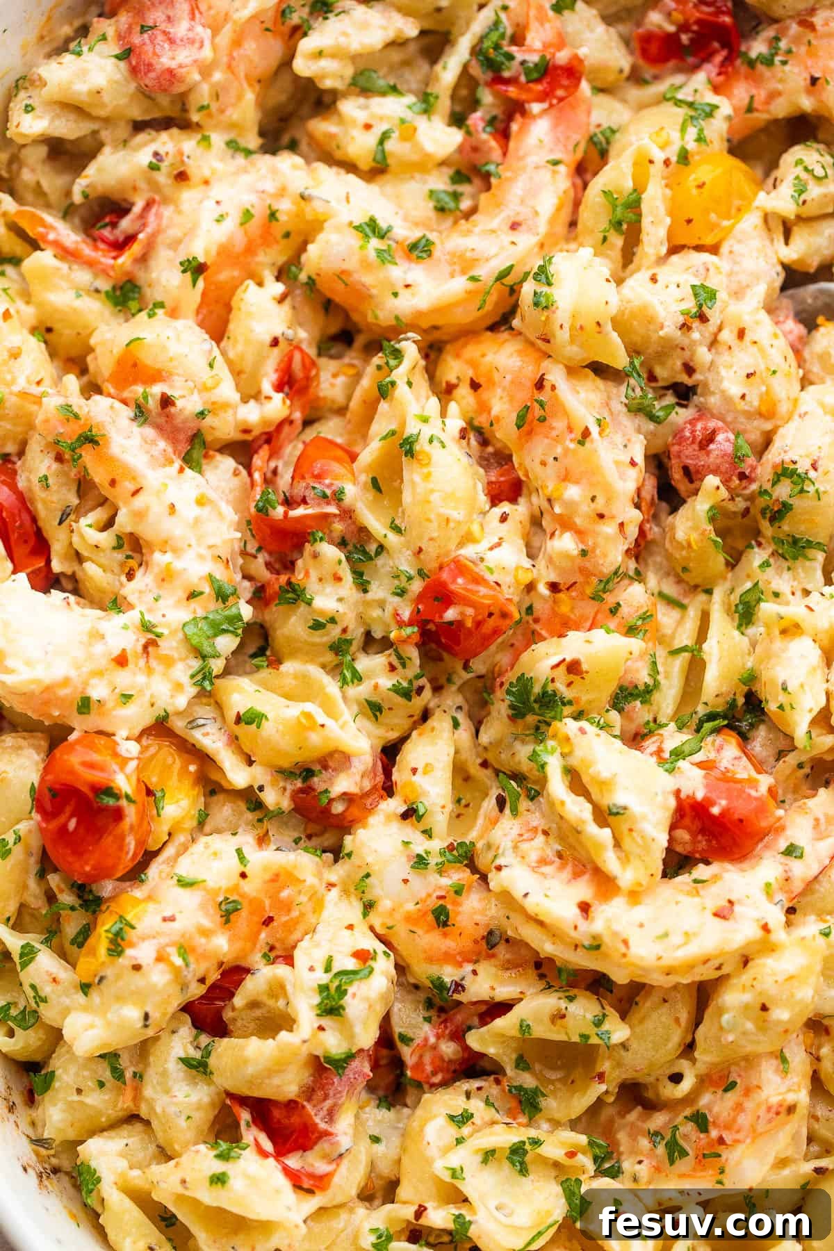Rich Cream Cheese Shrimp Pasta Bake 6 A wider shot of the shrimp and pasta tossed with cream cheese sauce and cherry tomatoes in a white baking dish.
