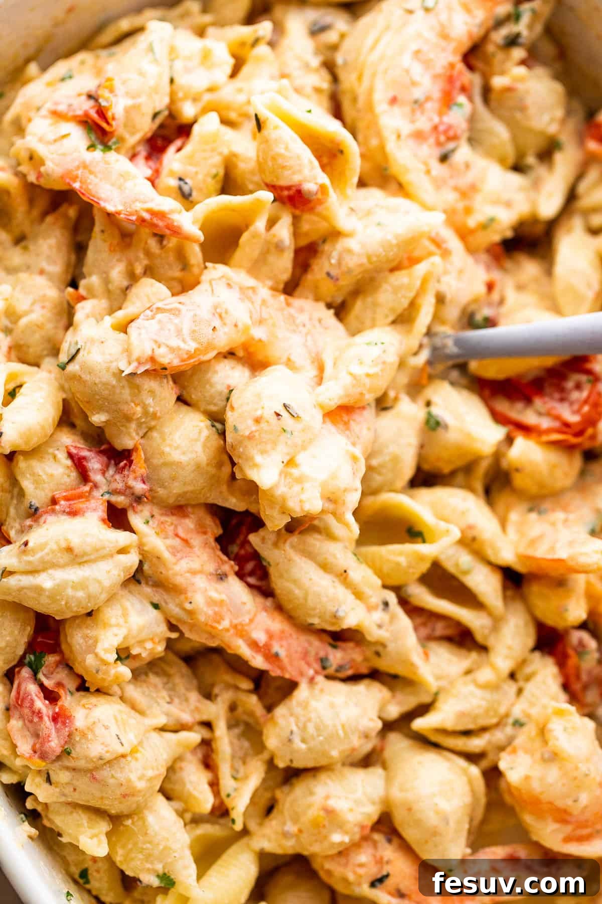 Rich Cream Cheese Shrimp Pasta Bake 7 Overhead view of the baked cream cheese pasta with shrimp in a serving bowl, garnished with fresh herbs.