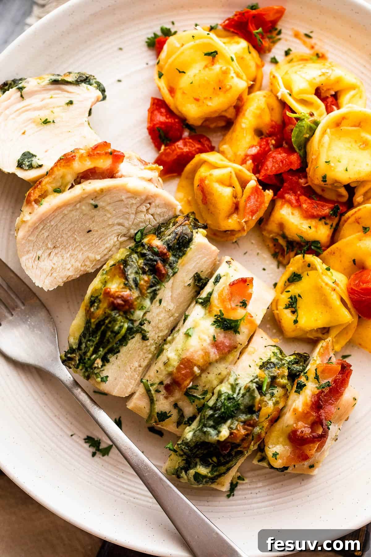 Decadent Cheesy Spinach Bacon Stuffed Chicken 2 cut up stuffed chicken breast served alongside tortellini pasta