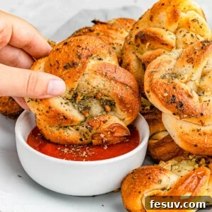 dipping garlic knots in marinara sauce.