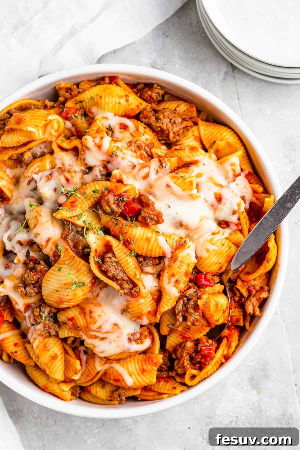 A full serving dish of Instant Pot pasta shells and ground beef in tomato sauce, topped with melted mozzarella, ready to be served.