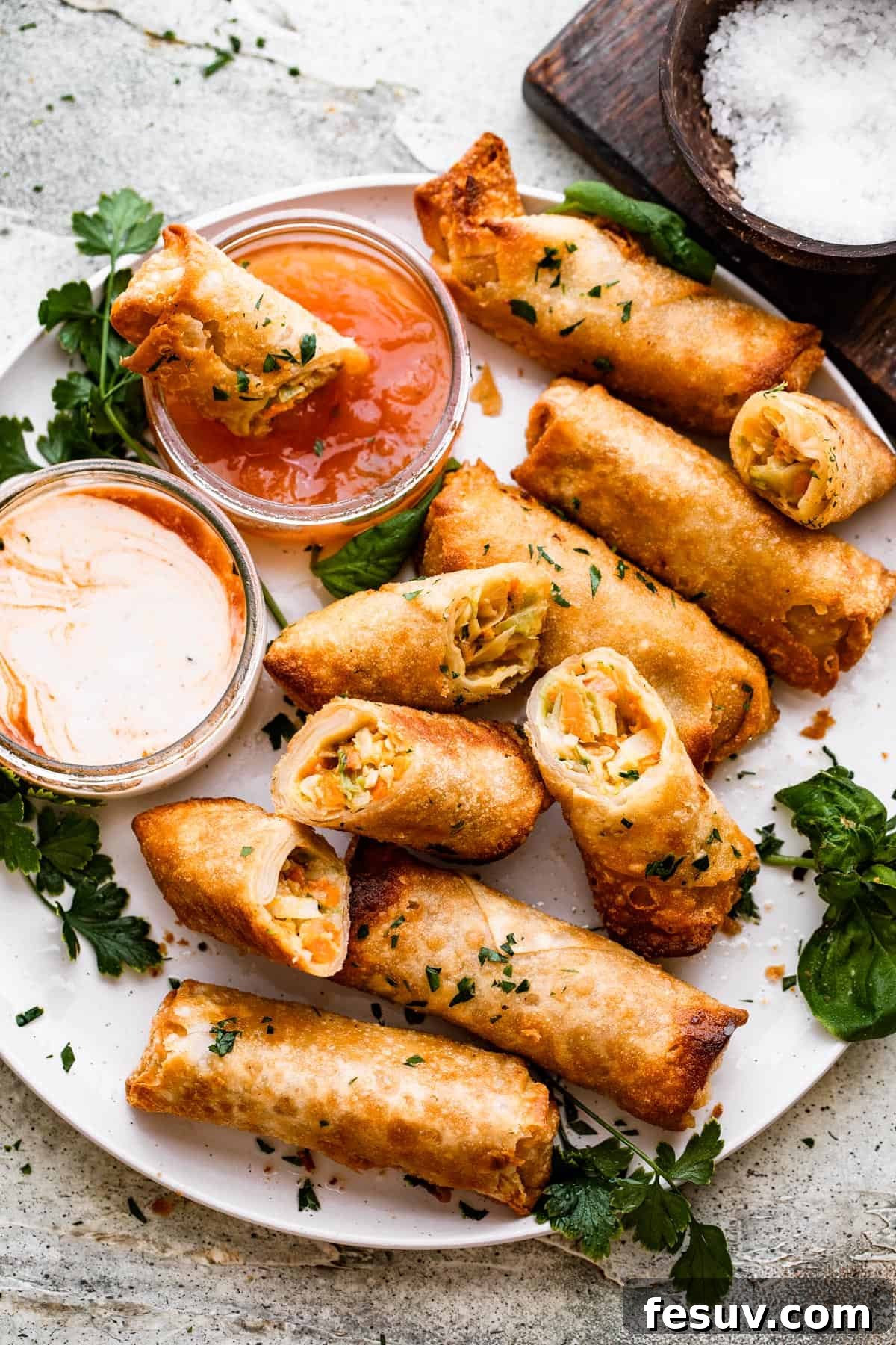 Sun-Kissed Vegetable Spring Rolls 8 A small collection of crispy spring rolls elegantly arranged on a plate, accompanied by a side of vibrant dipping sauce.
