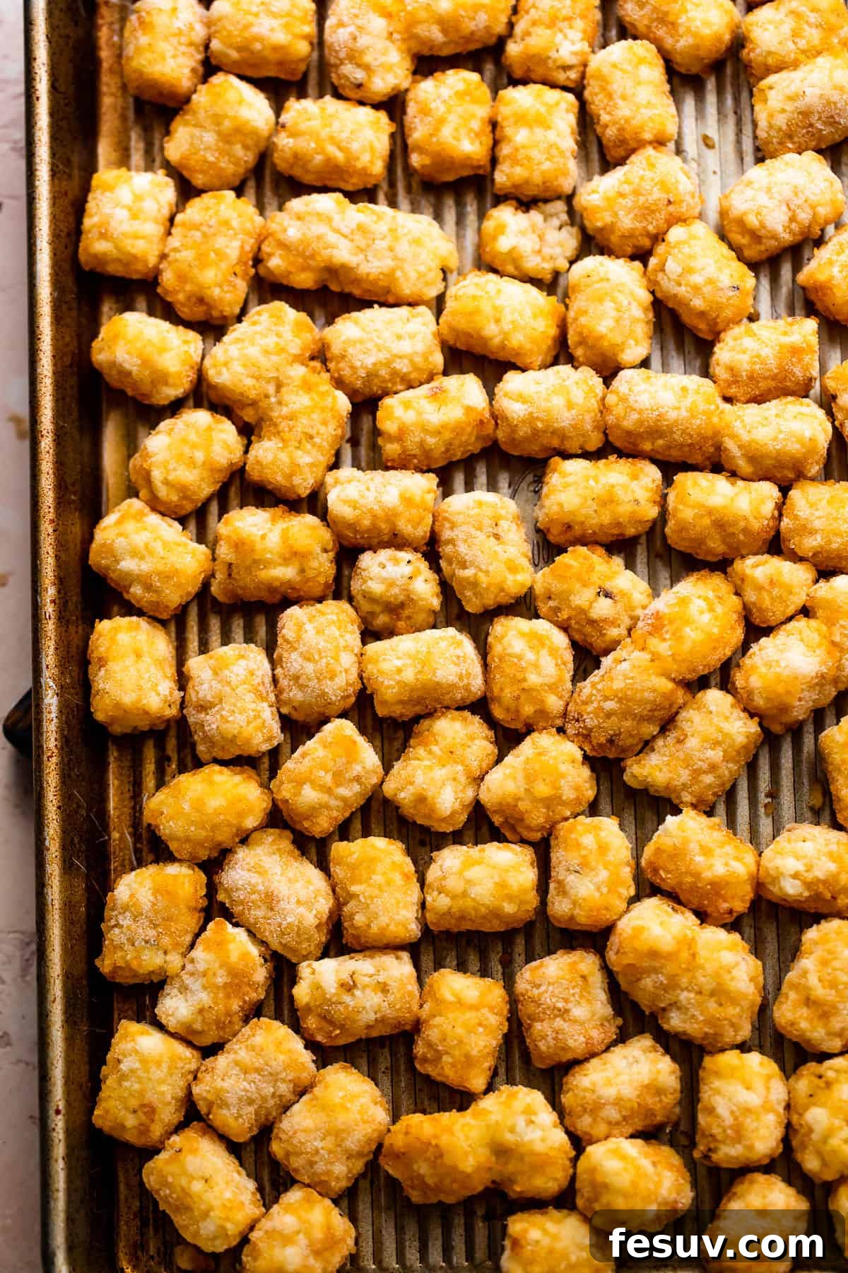 Loaded Sheet Pan Beef Totchos 4 A baking sheet filled with perfectly golden, crispy tater tots, ready for the next layer of savory toppings.