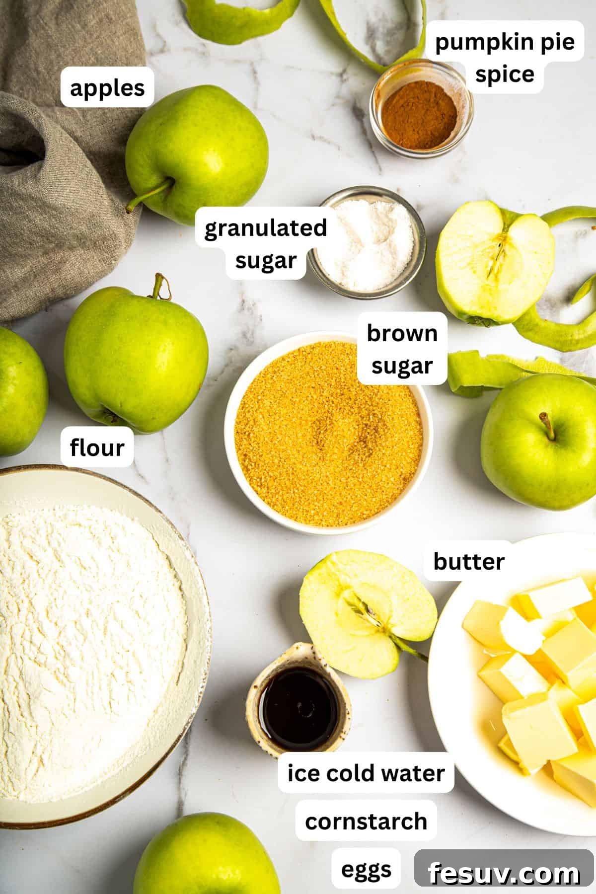This classic yet easy and delicious Apple Pie recipe is made from scratch, with a buttery, flaky pie crust, fresh apple slices, pie spices, and brown sugar. A vibrant flat lay of all the essential ingredients laid out on a kitchen counter, ready to make a homemade apple pie, including fresh apples, flour, butter, sugar, and spices.