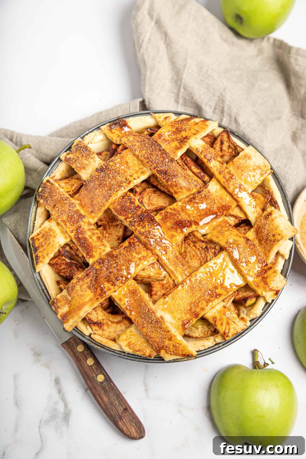 This classic yet easy and delicious Apple Pie recipe is made from scratch, with a buttery, flaky pie crust, fresh apple slices, pie spices, and brown sugar. A freshly baked homemade apple pie with a golden, flaky lattice top, cooling on a wire rack.