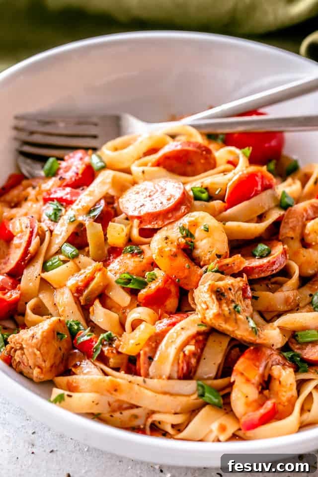 A vibrant One Pot Jambalaya Pasta dish served in a white bowl, showcasing chicken, sausage, shrimp, and pasta.