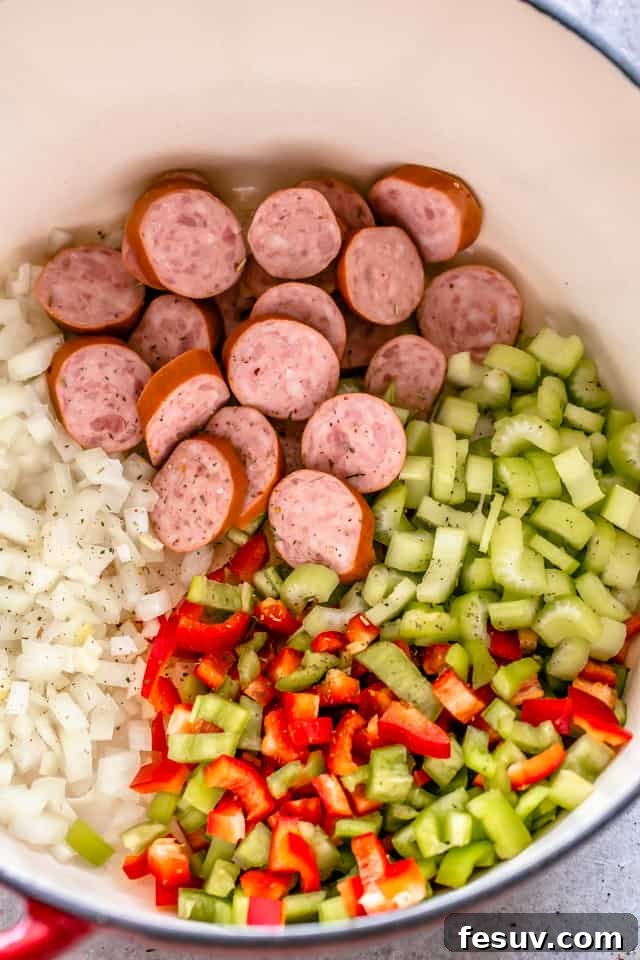 Diced onions, celery, and bell peppers in a dutch oven, lightly sautéed, ready for the next step of the recipe.