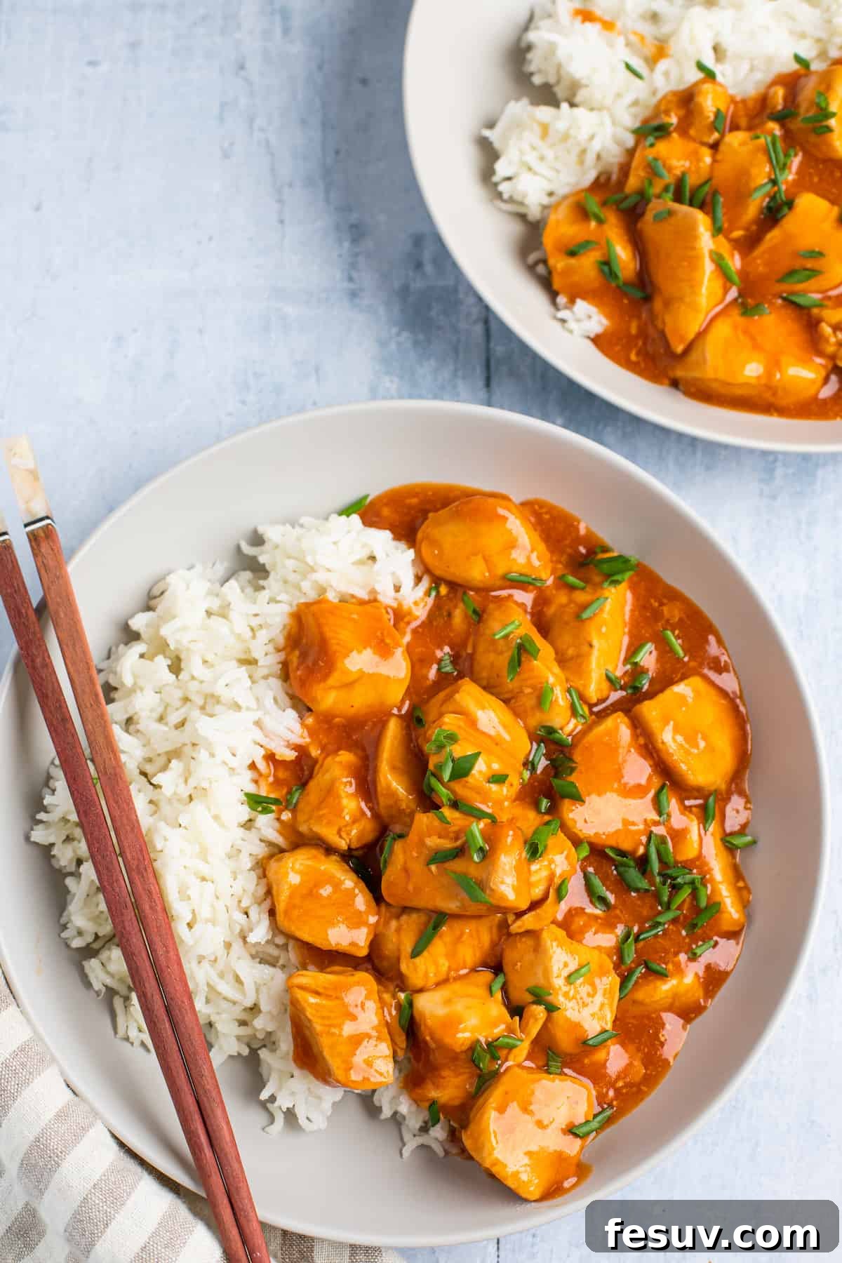 Two plates, each holding a generous serving of Instant Pot Orange Chicken and rice, ready to be enjoyed.