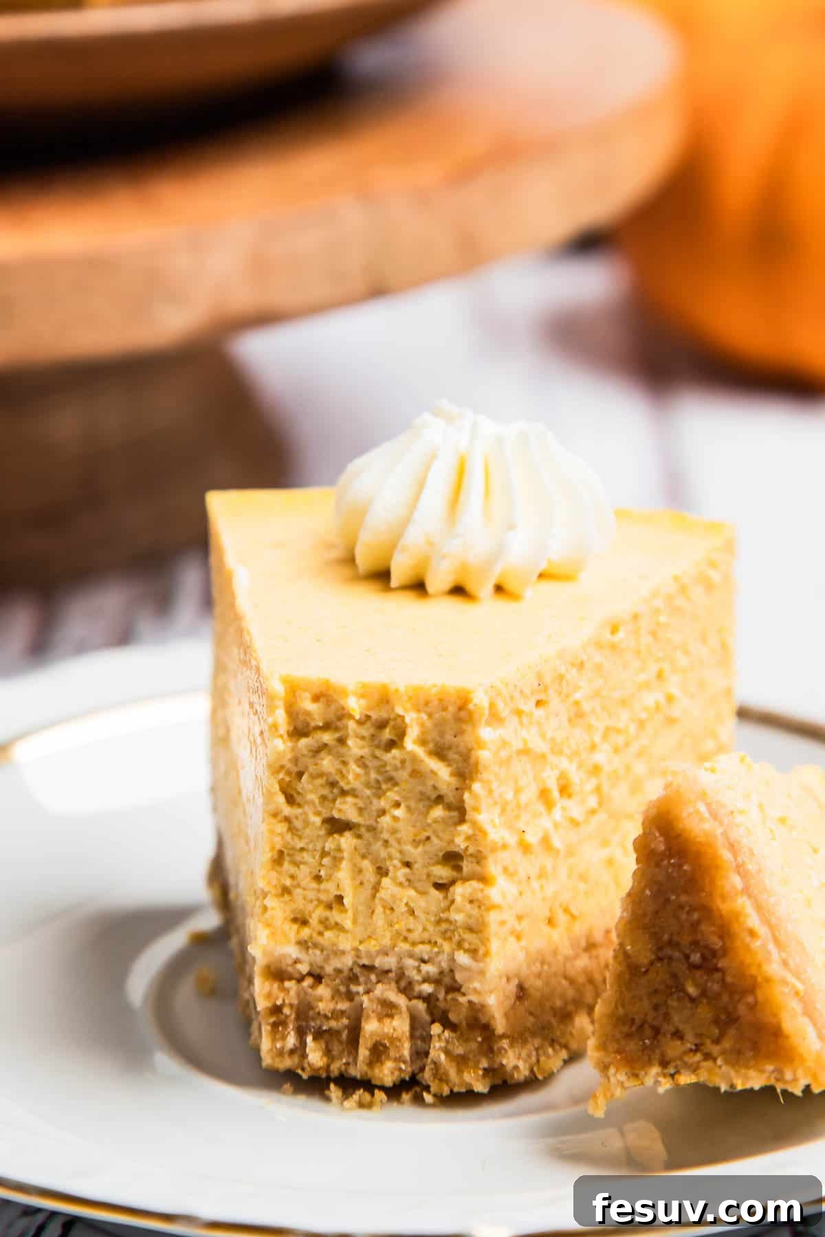 Creamy Instant Pot Pumpkin Cheesecake Bliss 8 A beautifully decorated Instant Pot Pumpkin Cheesecake slice on a rustic wooden board, garnished with spices and autumn leaves.