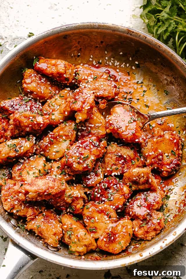 Our honey sesame chicken is better than take out! Crispy chicken pieces coated in a sweet and sticky sesame chicken sauce with huge flavor! Crispy Honey Sesame Chicken being stirred in a pan
