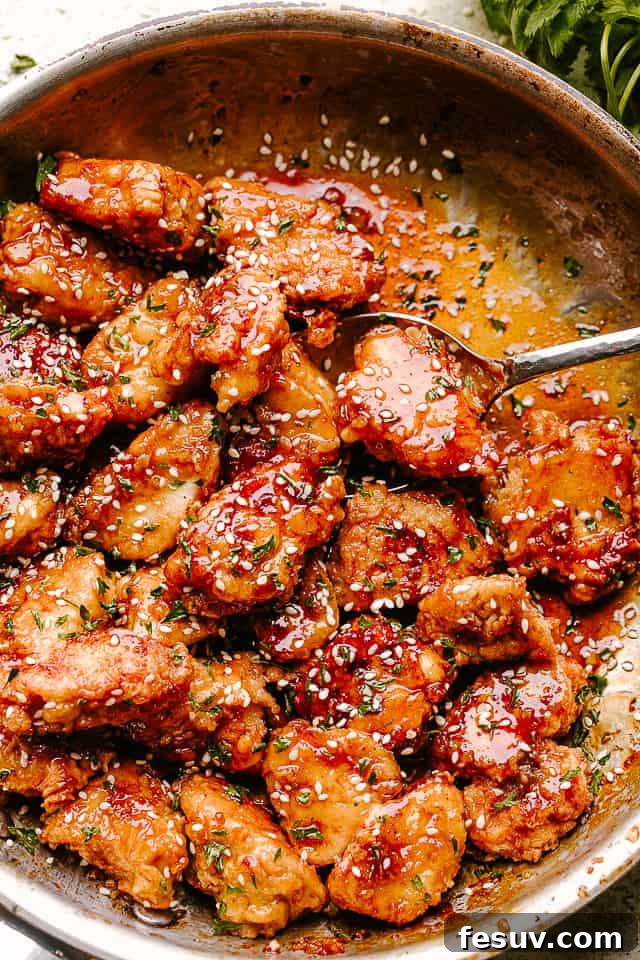 Our honey sesame chicken is better than take out! Crispy chicken pieces coated in a sweet and sticky sesame chicken sauce with huge flavor! Crispy Honey Sesame Chicken being stirred in a pan