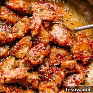 Crispy Honey Sesame Chicken being stirred in a pan