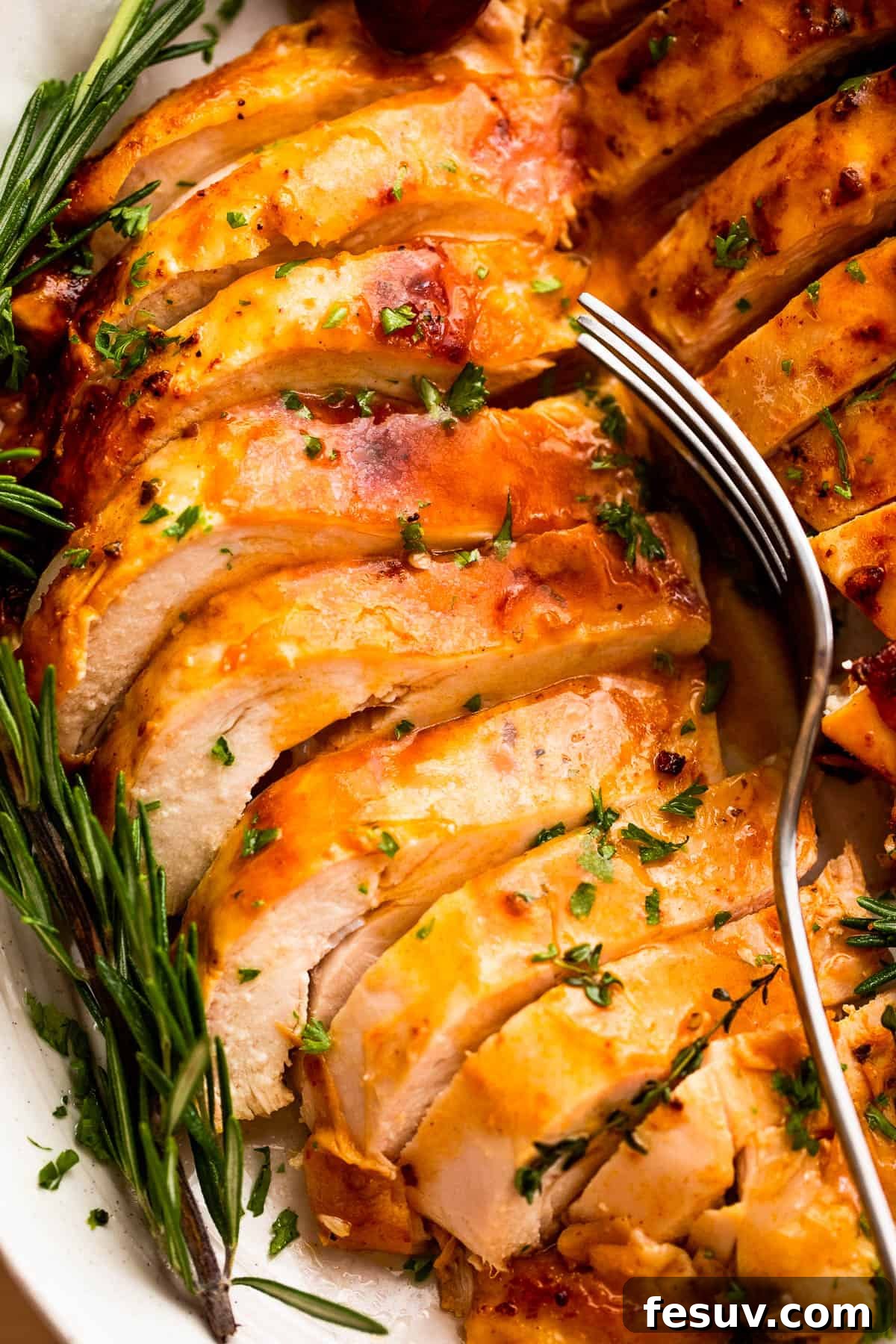 Perfectly Roasted Turkey Breast 2 sliced cooked turkey breast with a fork set over it.