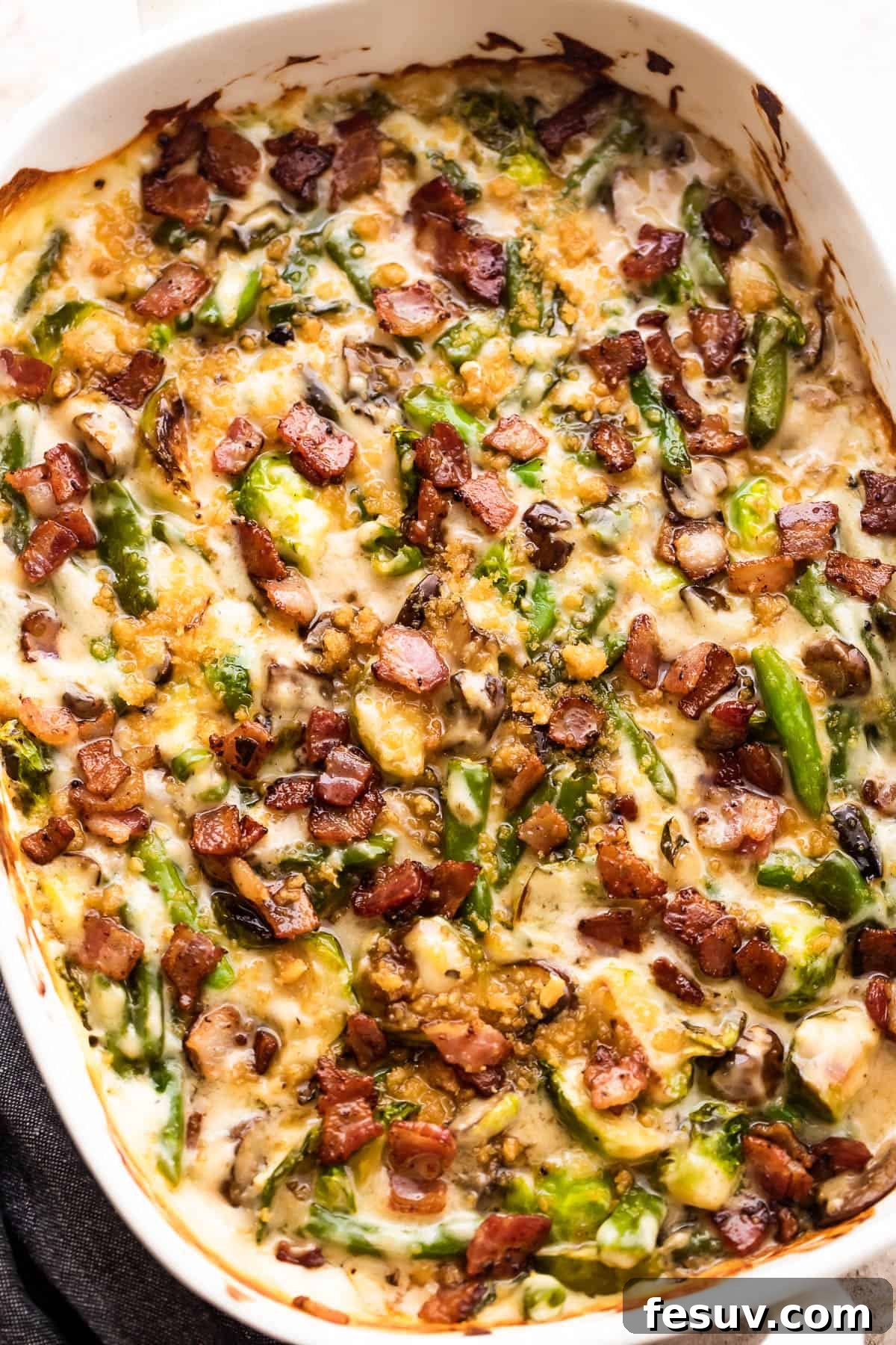 Gourmet Green Bean Casserole with Crispy Topping An inviting overhead view of the finished green bean and Brussels sprouts casserole, generously topped with crispy bacon bits and golden breadcrumbs.