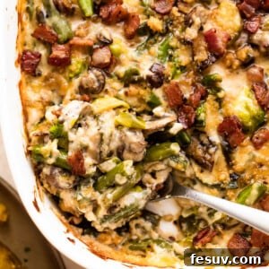 Ultimate Green Bean Casserole 2 A serving spoon lifting a portion of the rich, homemade Green Bean Casserole from a white baking dish, showcasing its creamy texture and crispy topping.