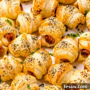 Hand-Wrapped Sausage Bites 2 Close up shot of crescent roll hot dogs sprinkled with sesame and poppy seeds.