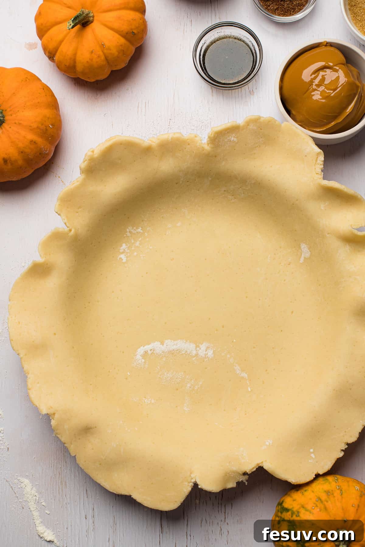 A pie plate carefully lined with homemade pie crust, awaiting trimming and filling, showcasing the rustic charm of scratch baking.
